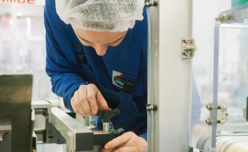 Mechanik údržby seřizuje výrobní stroj v závodě Hügli v Zásmukách